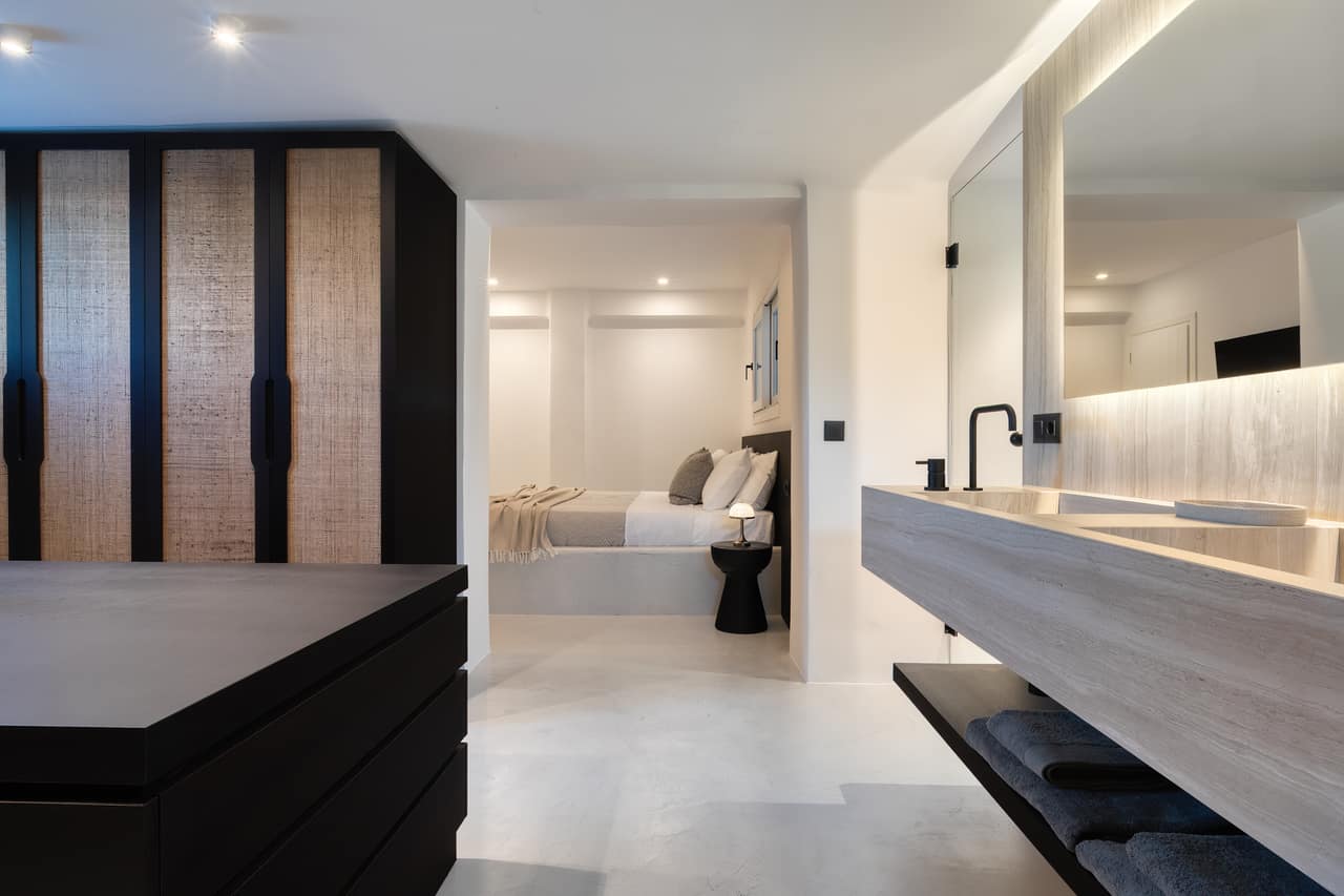 An en suite with a stone basin and woven wardrobe doors